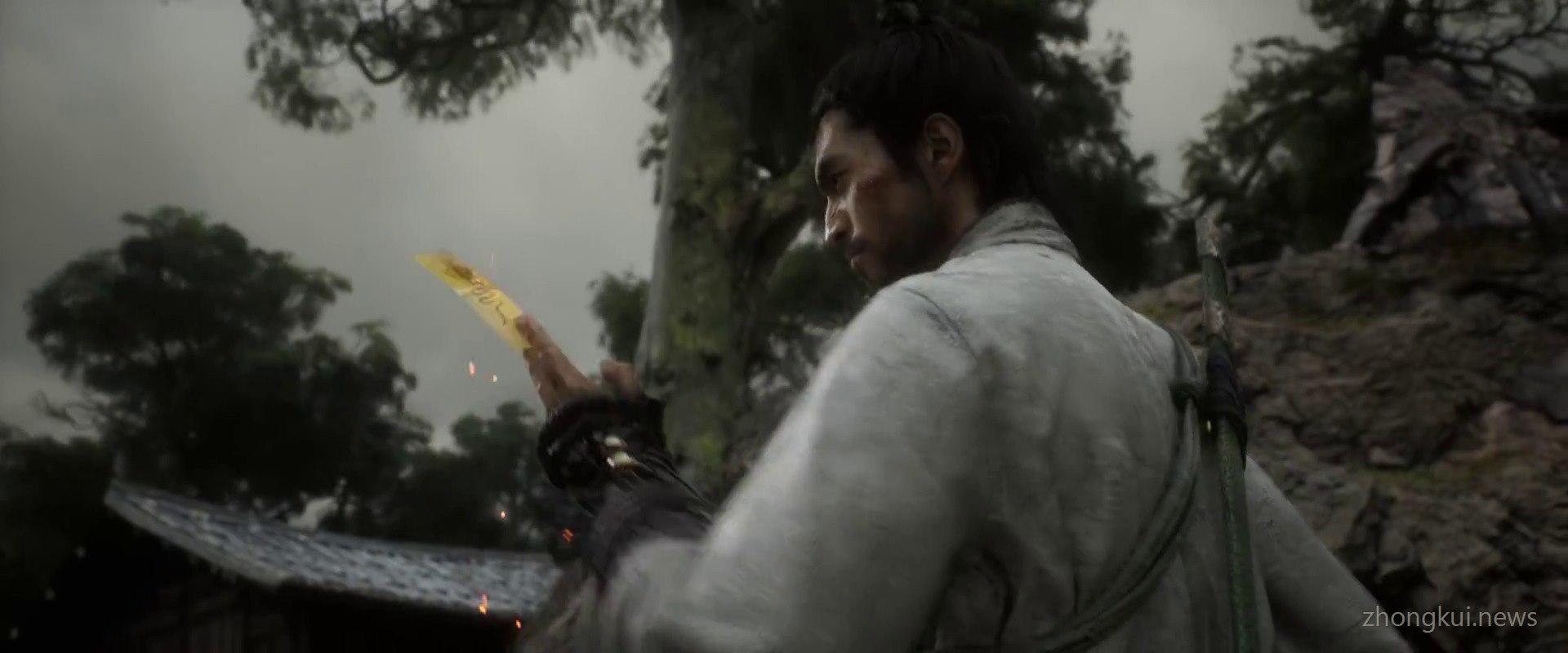 The swordsman casting a burning yellow paper talisman to catch a creature in a mountain village